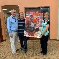 Glen Stucki  presenting his Spiderman painting to the Library Director