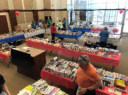 a room full of books on tables for sale.