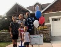 Parents and three children in front of a house