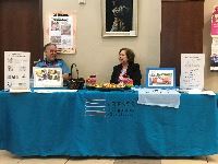 two people sitting at an information booth