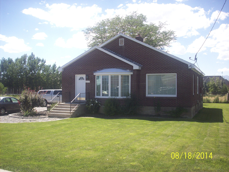 Red house with a green lawn on a sunny day
