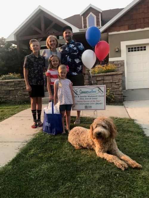 Parents and three children in front of a house